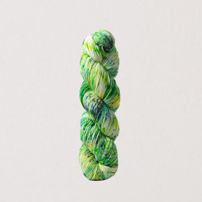 Green and white skein of yarn on a light gray background