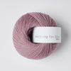 Pink skein of yarn with a label on a white background