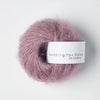 Ball of pink yarn with a label on a white background