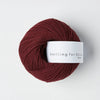 Burgundy skein of yarn with a 'Knitting for Olive' label on a white background