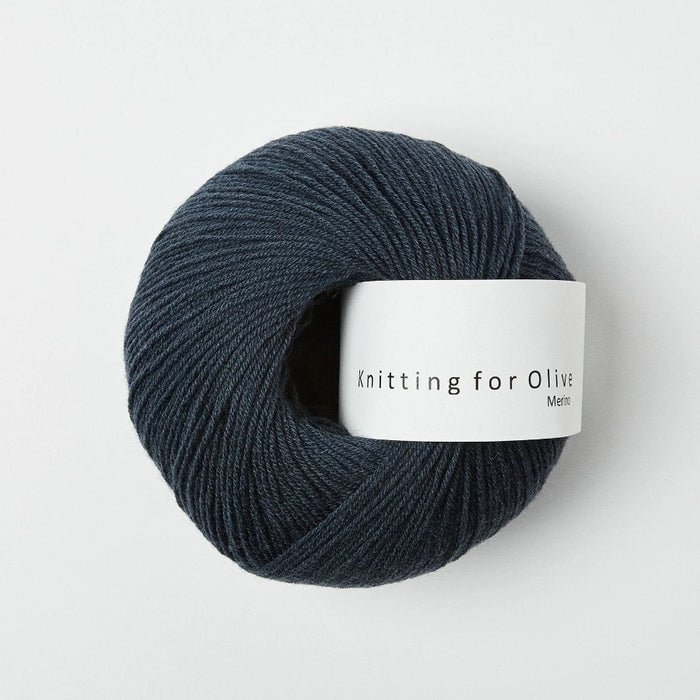 Ball of dark blue yarn with a label on a white background