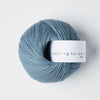 Blue skein of yarn with a label on a white background
