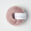Ball of pink yarn with a label on a white background