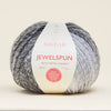 Ball of Sirdar Jewelspun yarn with a white label on a beige background