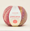 Sirdar Jewelspun yarn ball with label on a light beige background