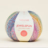 Multicolored ball of yarn with a Sirdar label on a beige background