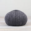 Ball of gray yarn on a light wooden surface