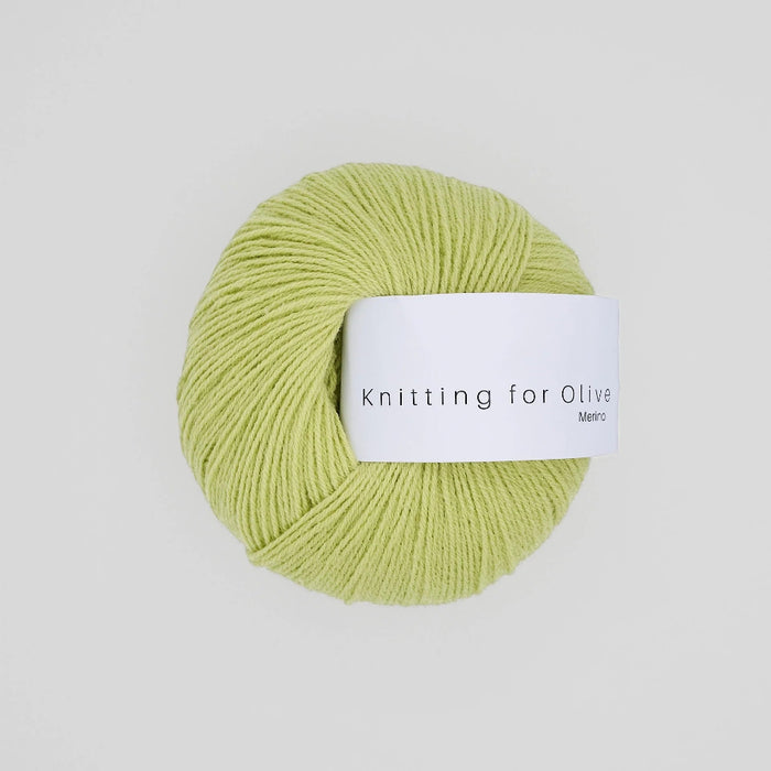 Ball of green yarn with a label on a light gray background