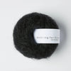 Ball of dark yarn with a label on a white background