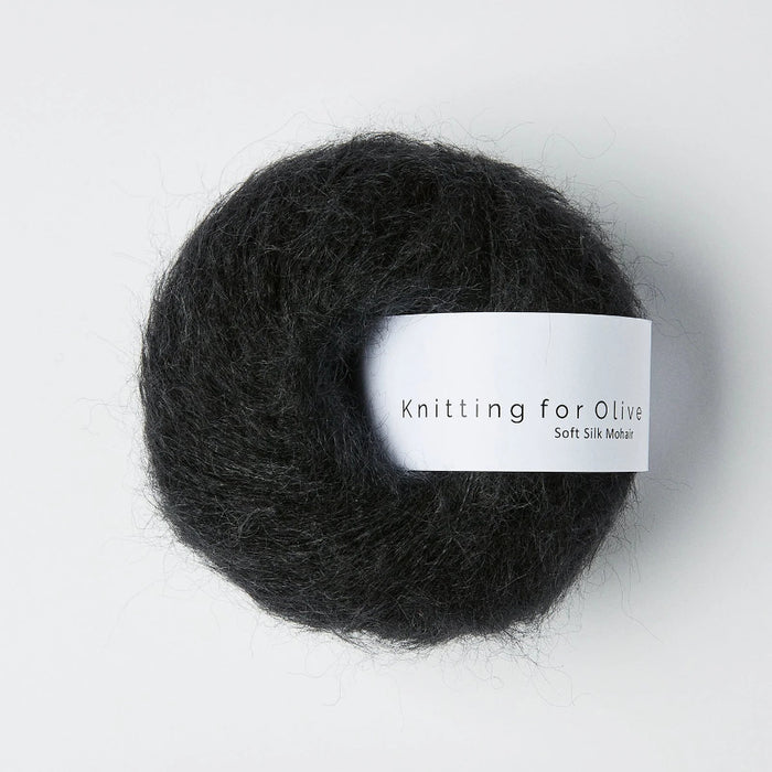 Ball of dark yarn with a label on a white background