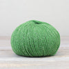 Green skein of yarn on a light wooden surface