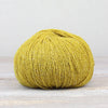 Yellow skein of yarn on a light wooden surface