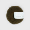 Ball of dark green yarn with a label on a white background