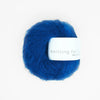 Blue yarn ball with a label on a white background