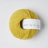 Yellow skein of yarn with a 'Knitting for Olive' label on a white background
