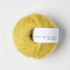 Ball of yellow yarn with 'Knitting for Olive' label on a white background