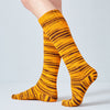 Yellow striped socks worn by a person on a light gray background