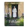 Book cover of 'Folklore' by West Yorkshire Spinners with a woman in a white knitted jumper standing in front of a door.