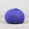 Blue skein of yarn on a light wooden surface