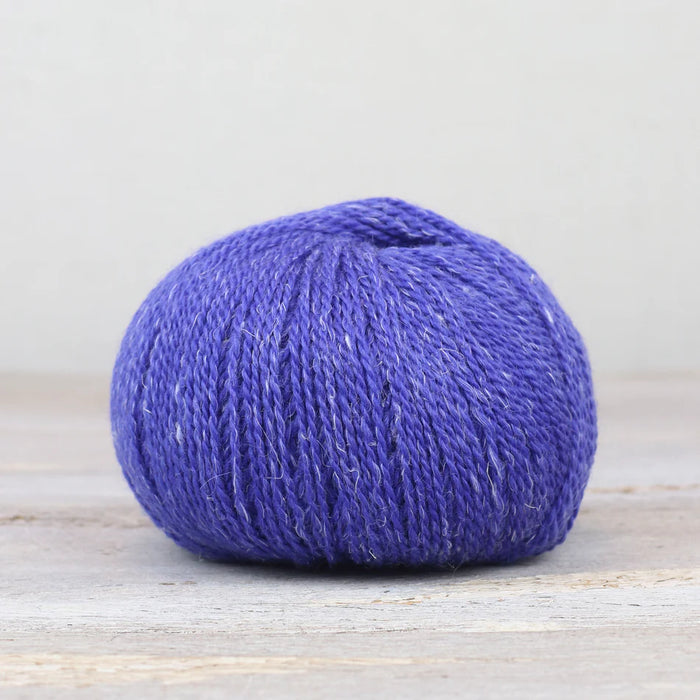 Blue skein of yarn on a light wooden surface