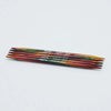 Set of colorful knitting needles on a light gray background