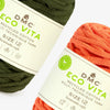 Two skeins of DMC Eco Vita yarn, one green and one orange, on a white background.